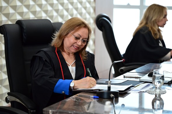 TRE-CE empossa Edilberto Oliveira e José Cavalcante Júnior como membros titulares do Pleno A imagem mostra a presidente Maria Iraneide sentada em uma cadeira preta enquanto assina um pape...