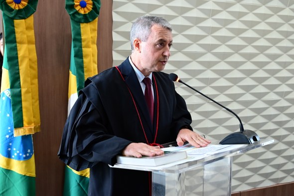 TRE-CE empossa Edilberto Oliveira e José Cavalcante Júnior como membros titulares do Pleno A imagem mostra o juiz Edilberto atrás de um púlpito de acrílico discursando. Sobre o púlpito, h...