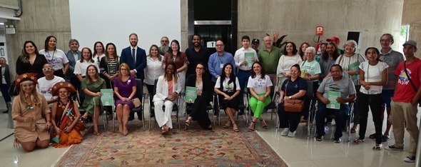 TRE-CE oferece serviços eleitorais em evento alusivo ao Dia de Luta da População em Situação de Rua Na imagem, um grupo de pessoas posa para a foto, algumas sentadas e outras em pé.
