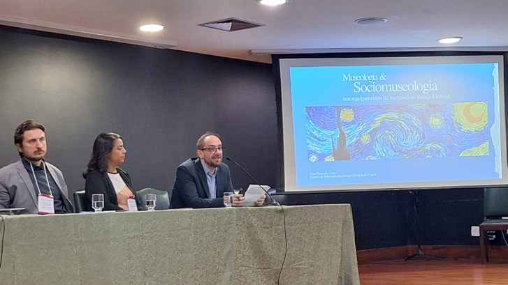 TRE-CE participa de eventos sobre memória do Poder Judiciário As duas imagens mostram um auditório onde ocorre um evento institucional. Na primeira imagem, tr...