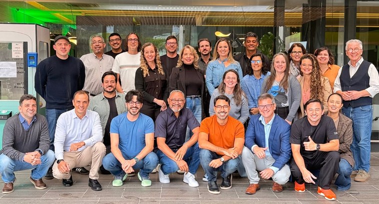 Registro fotográfico feito durante o evento. Nele, 26 pessoas posam para a foto.