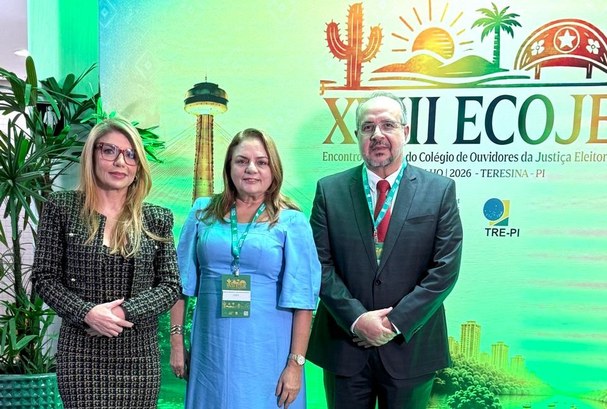 Na primeira foto, três representantes da Justiça Eleitoral cearense posam em frente ao painel of...