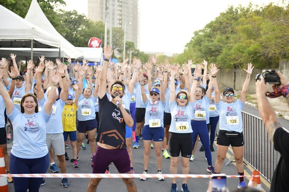 TRE-CE realiza 2ª Corrida/Caminhada da Justiça Eleitoral cearense Na foto, os participantes da ação estão com braços levantados, sorrindo. Há um instrutor à frent...
