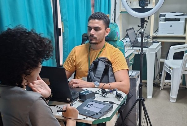 TRE-CE realiza atendimentos em ação da CMFor, no Centro de Fortaleza A imagem mostra um atendimento eleitoral em andamento dentro do ônibus do TRE-CE. Um eleitor est...