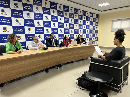 TRE-CE realiza sessão de validação da autodeclaração racial para o Hackathon Registro fotográfico feito em uma sala ampla, na sede do TRE-CE. No primeiro registro, há uma me...