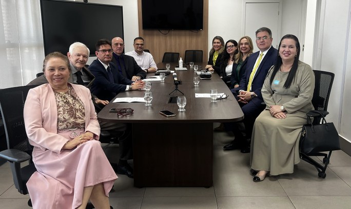 TRE-CE regulamenta atuação de advogados(as) nos locais de votação em parceria com a OAB-CE A imagem exibe um grupo de pessoas reunidas em uma sala de reuniões com piso claro e paredes bra...