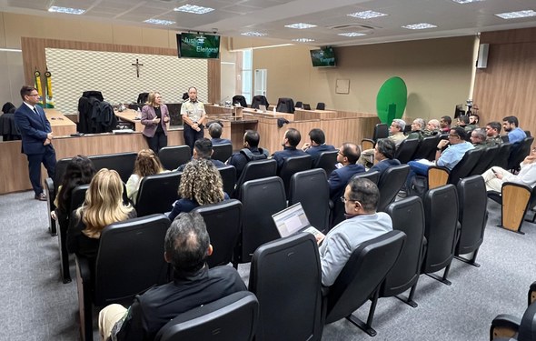 TRE-CE reúne forças de segurança locais e nacionais para tratar da eleição em Santa Quitéria Na imagem, o auditório está ocupado. Três pessoas estão em pé à frente, a presidente do TRE-CE e...