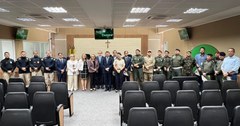 Na imagem, um grupo de cerca de 26 pessoas posa para uma foto. Estão presentes autoridades do Tr...