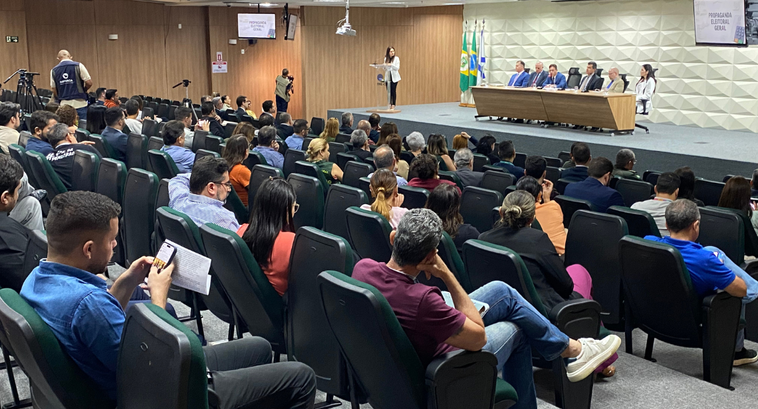 A imagem mostra o auditório do TRE Ceará durante uma reunião. Ao centro, há uma plateia formada ...