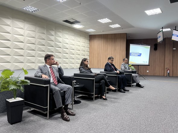TRE-CE reúne-se com partidos e imprensa para orientar sobre a propaganda eleitoral nas Eleições 2024 Na foto, quatro poltronas estão enfileiradas à frente do palco do Auditório. Há quatro pessoas s...