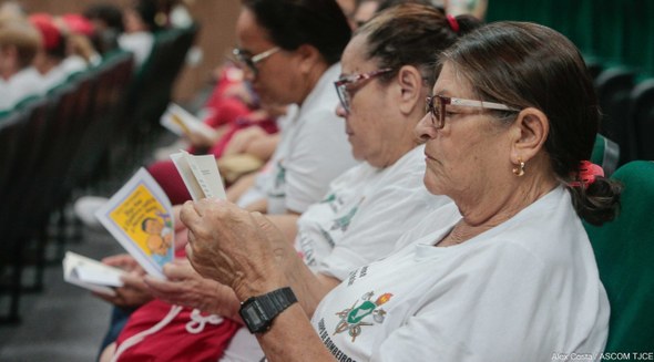 TRE-CE sedia o III Seminário Internacional sobre a Violência contra Pessoa Idosa Registro oficial feito durante o evento. Nele, mulheres estão sentadas lendo cordéis.