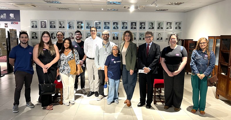 A imagem mostra um grupo de pessoas posicionadas em pé, lado a lado, no Centro de Memória do TRE...