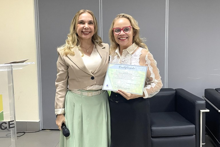 Na imagem, a diretora-geral, Orleanes Cavalcanti, e a servidora Rita de Cássia, estão em pé lado...