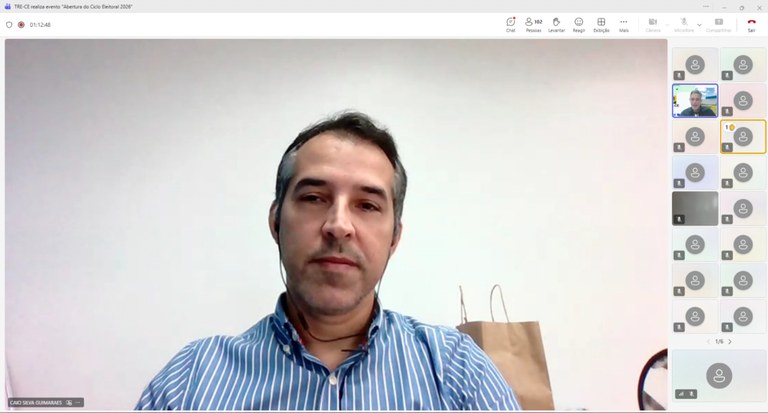 Na imagem, há a tela de um computador exibindo uma videoconferência. No centro, aparece o rosto ...